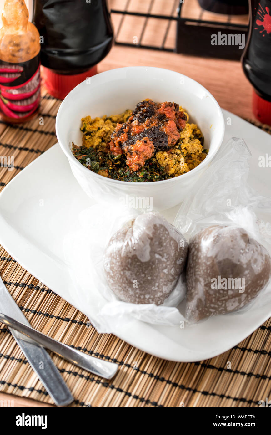 La nourriture régionale africaine sur plaque blanche sur fond de bois Banque D'Images