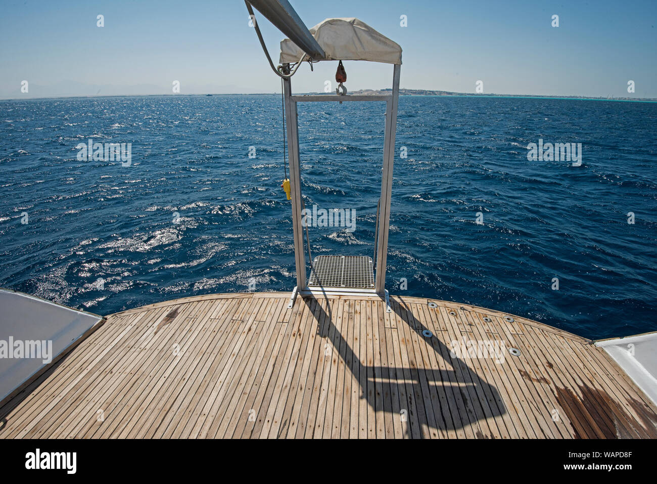 Metal steel diver ascenseur à l'arrière pont en teck d'un grand yacht de luxe la voile sur un océan tropical Banque D'Images