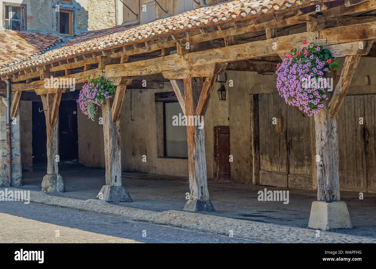 Revel, Midi Pyrénées, France - 5 août 2017 : Arcade et des colonnes en bois  en place médiévale avec des fleurs Photo Stock - Alamy