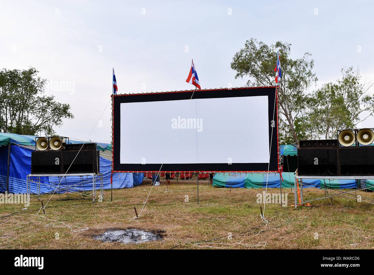 Outdoor écran de cinéma et un système de son sur le terrain ouvert dans le temple festival. Thaïlande Banque D'Images