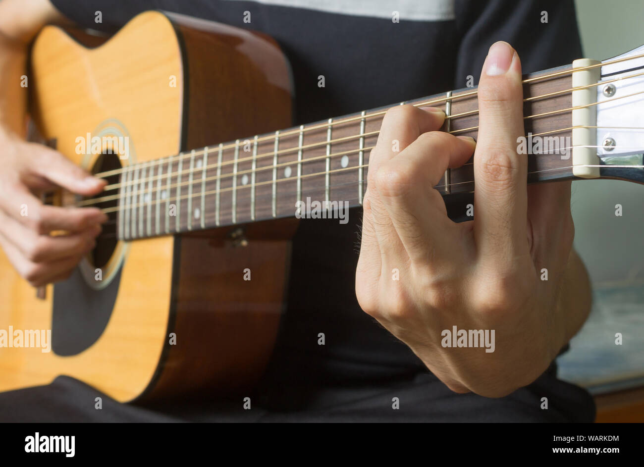 Main de joueur de guitare ou musicien de F d'accord sur des cordes de  guitare acoustique avec lumière naturelle en vue de côté Photo Stock - Alamy