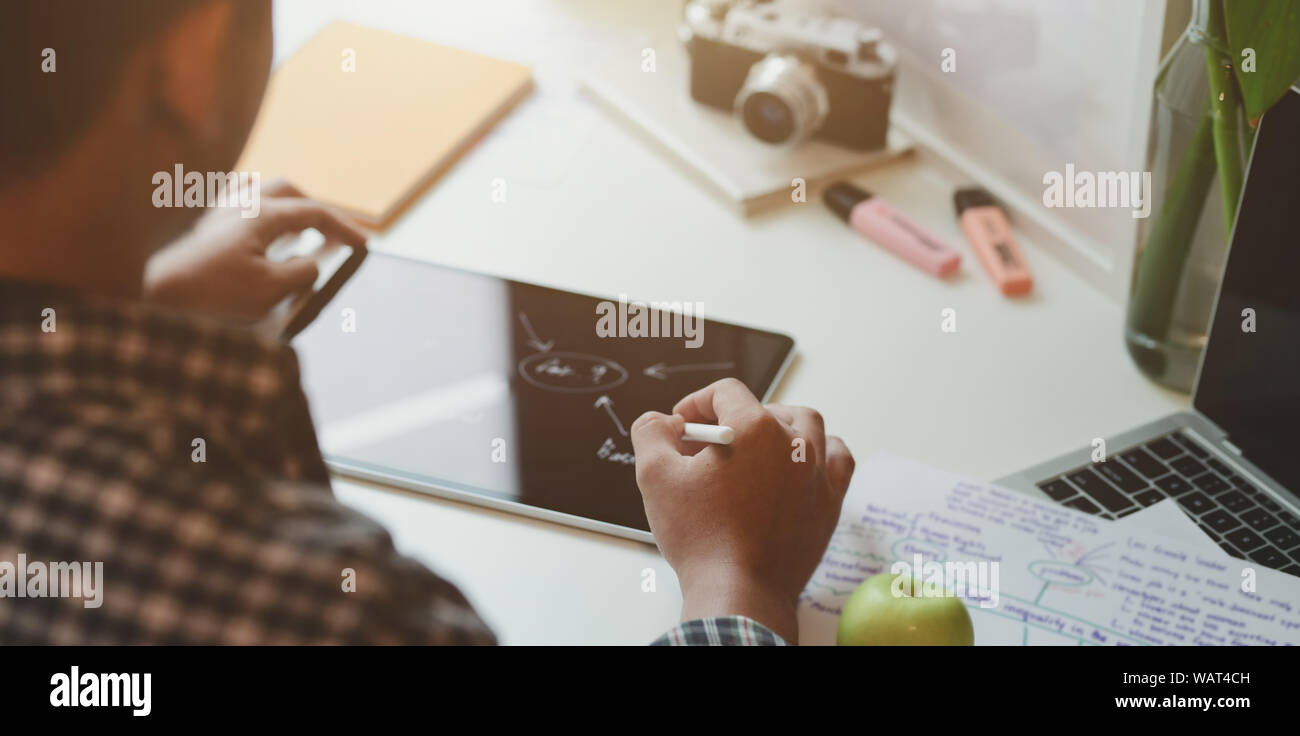Close-up of young designer dimensions mind mapping sur son projet sur tablet in room Banque D'Images