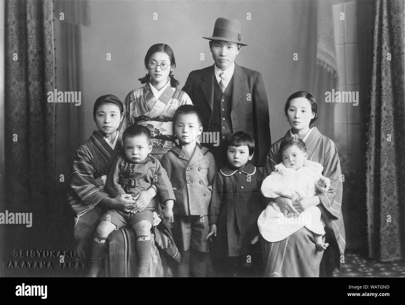 [ 1930 - Japon ] famille japonaise - famille japonaise avec mari dans un style occidental suite et les femmes en kimono. 20e siècle Tirage argentique d'époque. Banque D'Images