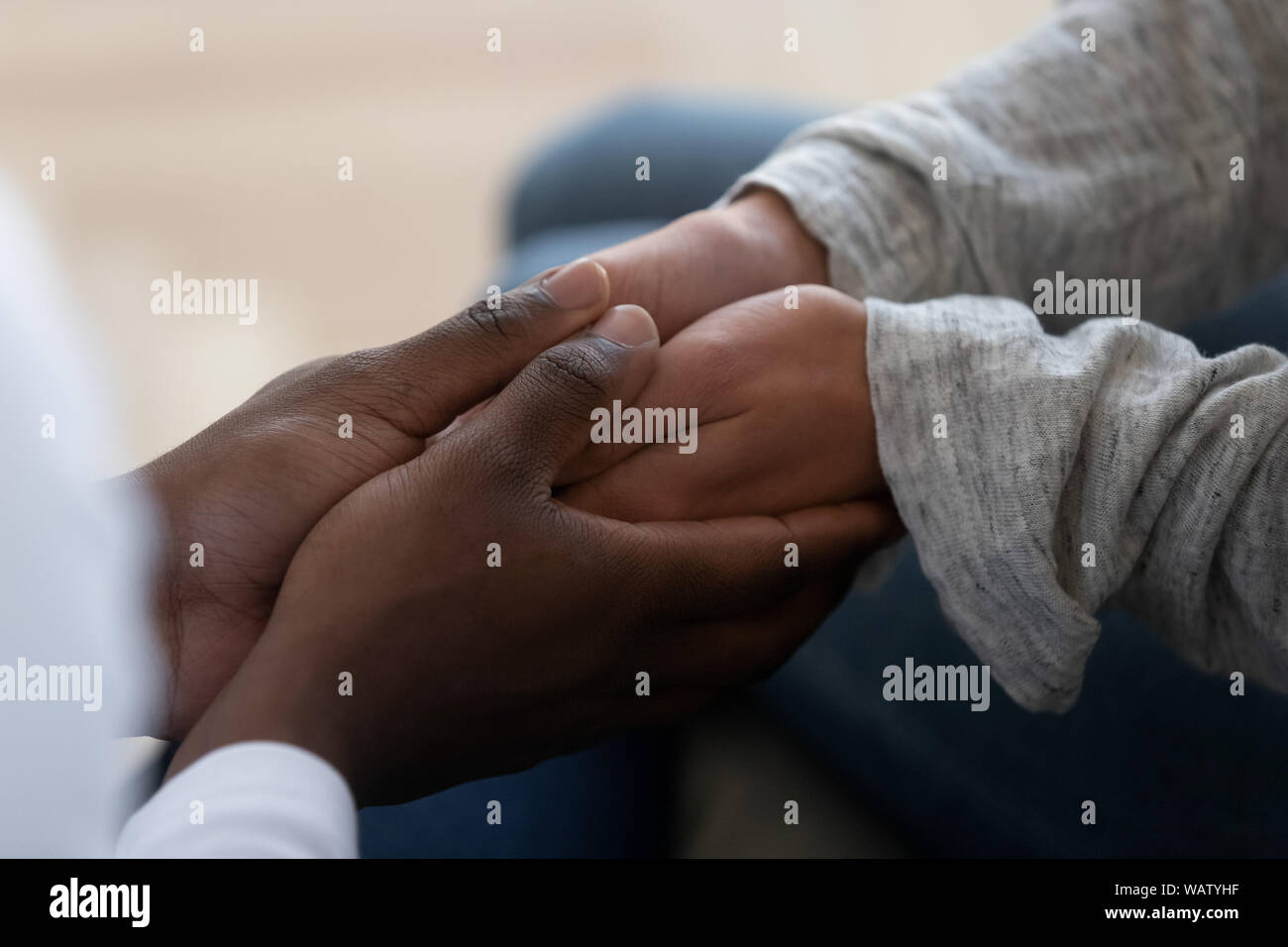 L'origine ethnique mixte famille couple holding hands exprimer leur soutien dans le mariage Banque D'Images
