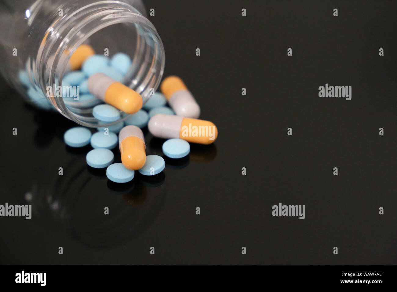 Comprimés dans une bouteille, des médicaments dans des capsules sur une table en verre. Concept de pharmacie, antibiotiques, vitamines Banque D'Images
