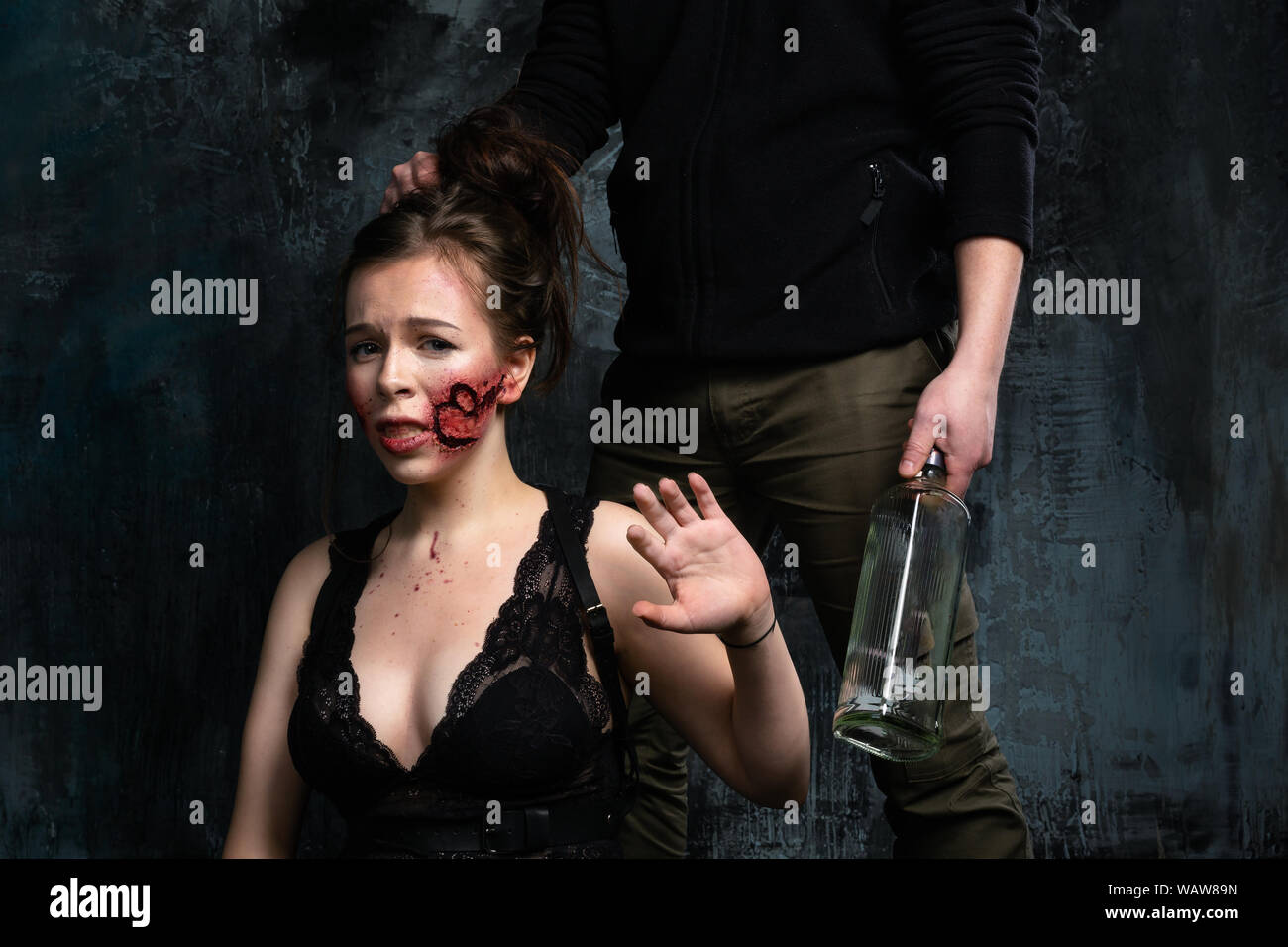 La violence dans la famille. Mari alcoolique fait mal sa femme et tenant  une bouteille de vodka dans sa main Photo Stock - Alamy