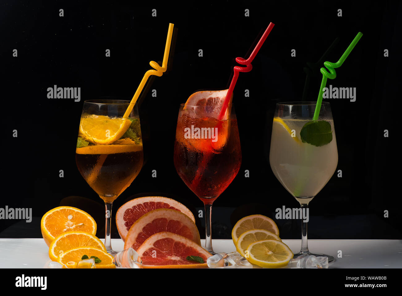 Coupe de fruits et verre à cocktail au bar. Parti et vacances d'été. Des boissons alcoolisées et des fruits au restaurant. Des cocktails sur fond noir. Verre et Banque D'Images