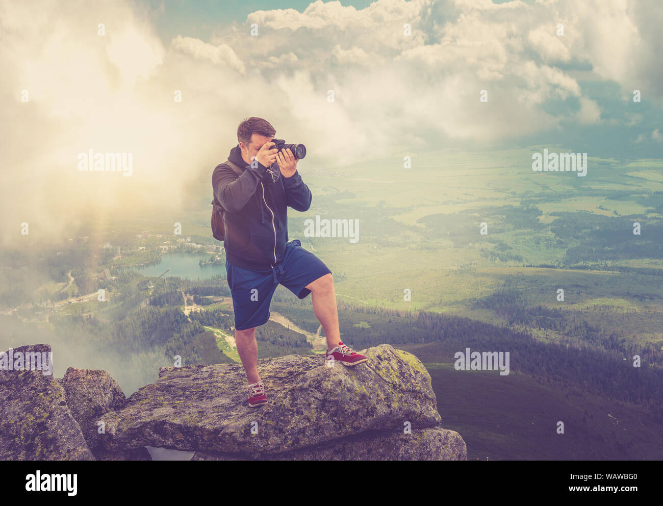 Un photographe sur le haut d'une falaise abrupte et skyline en haute montagne. Banque D'Images