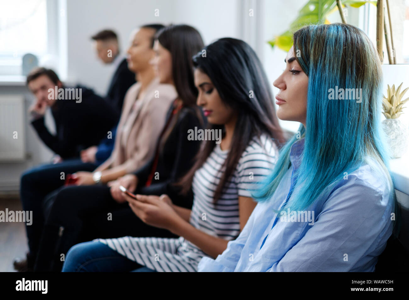 Groupe de jeunes en attente d'une entrevue d'emploi. Banque D'Images