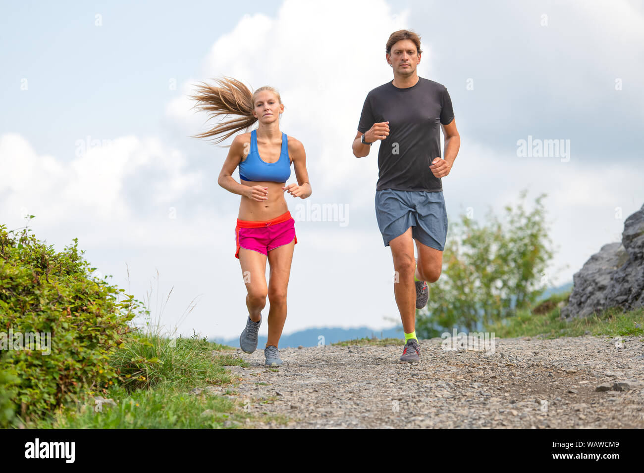 Couple de jeunes athlètes s'exécute sur chemin de terre. Banque D'Images