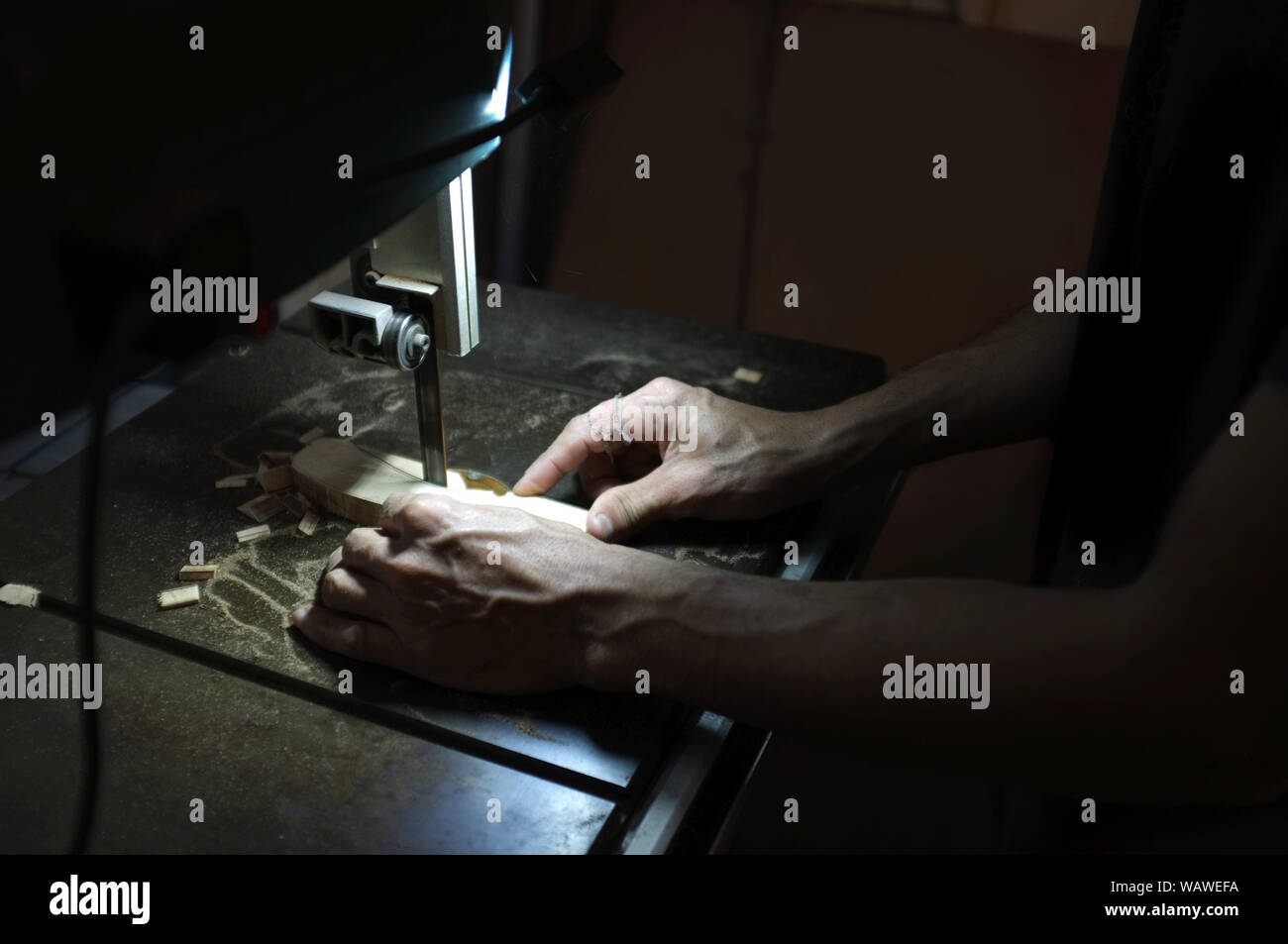 Carpenter builder travailler avec electric jigsaw et le bois. Menuisier couper un morceau de bois Banque D'Images