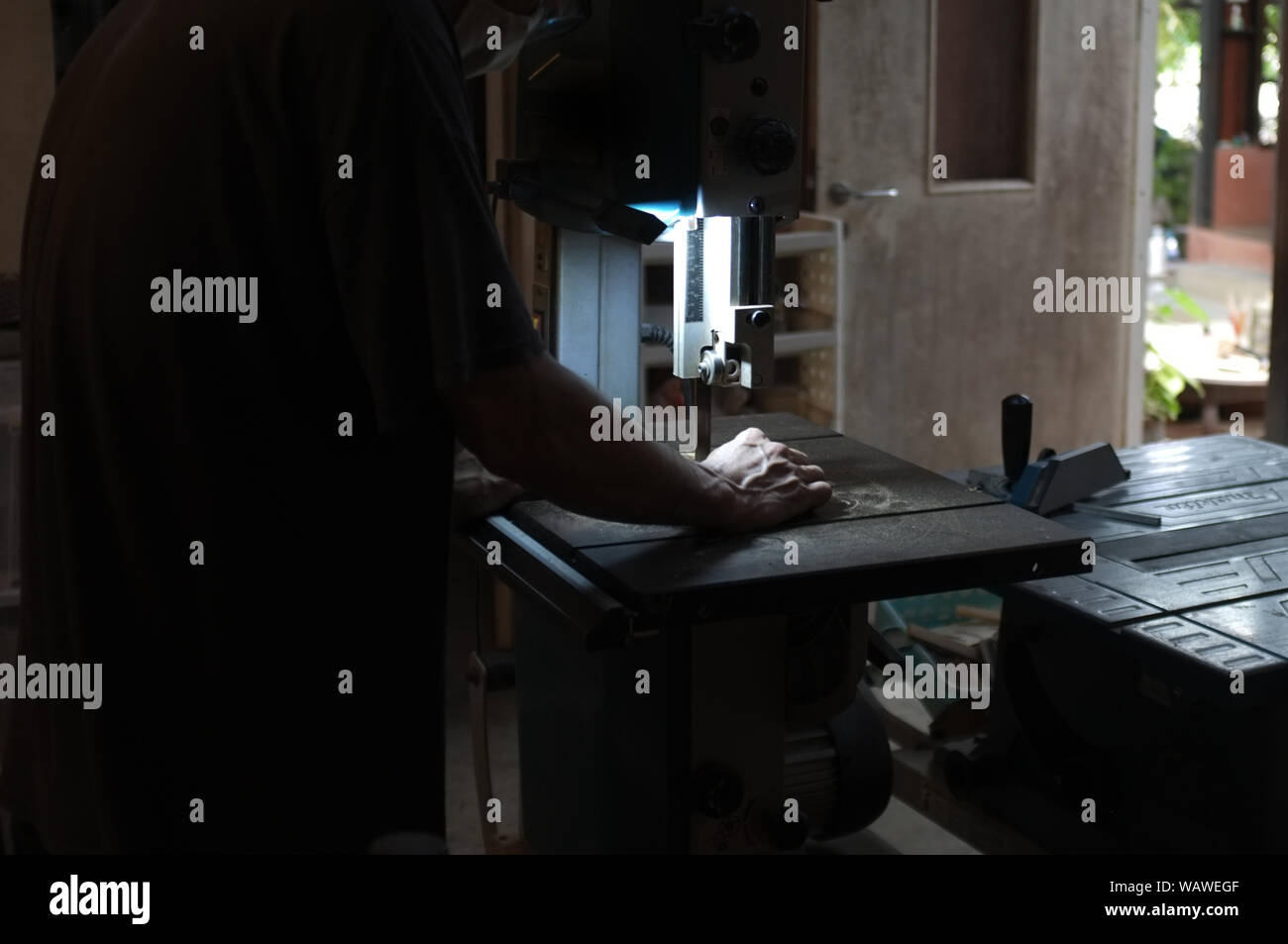 Carpenter builder travailler avec electric jigsaw et le bois. Menuisier couper un morceau de bois Banque D'Images