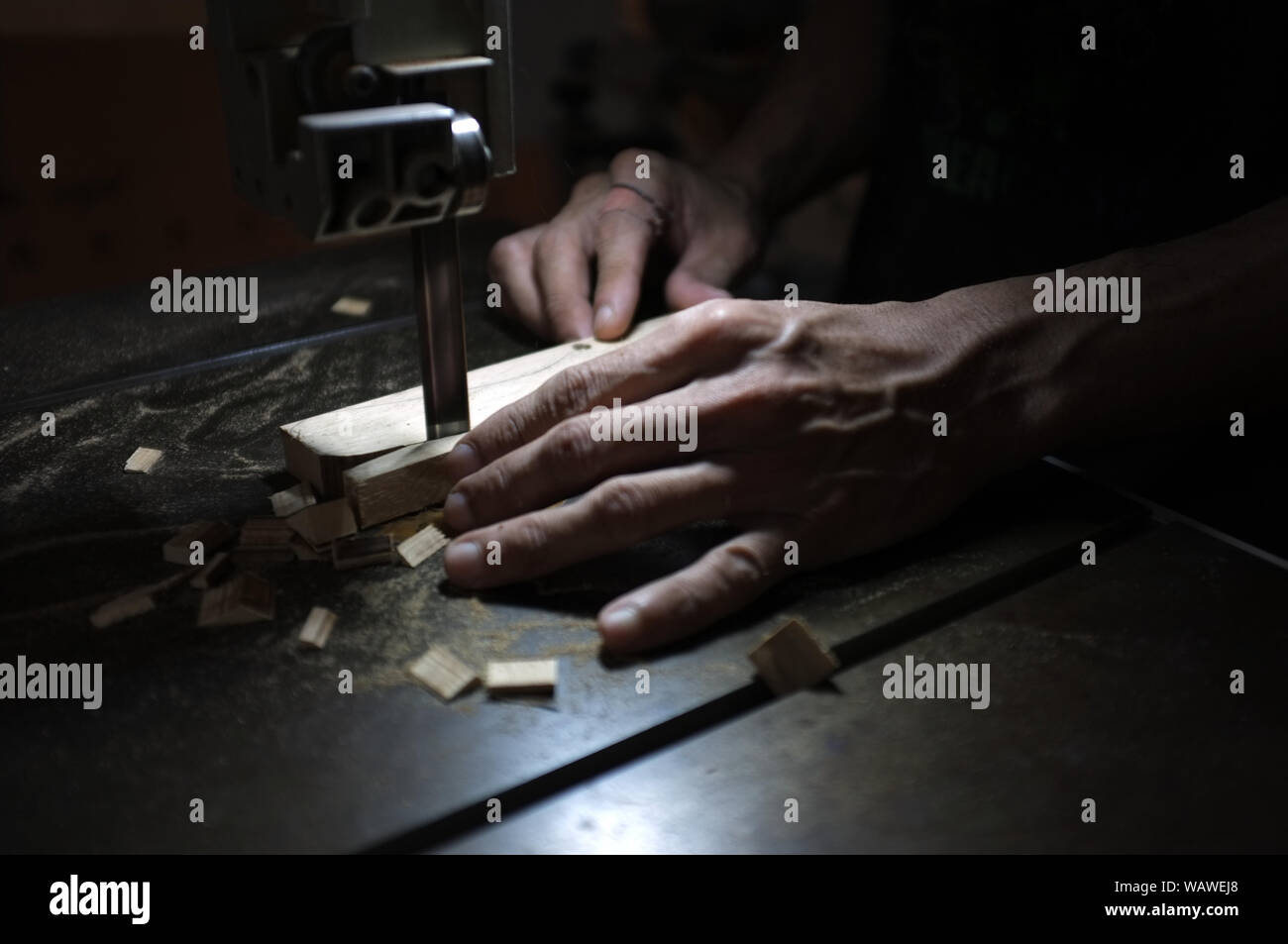 Carpenter builder travailler avec electric jigsaw et le bois. Menuisier couper un morceau de bois Banque D'Images