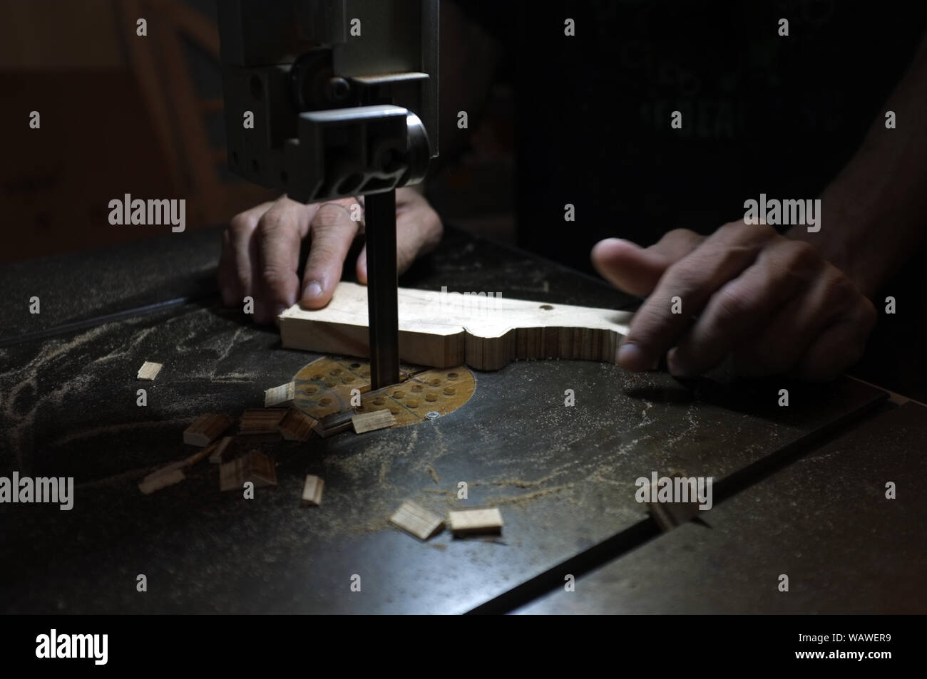 Carpenter builder travailler avec electric jigsaw et le bois. Menuisier couper un morceau de bois Banque D'Images
