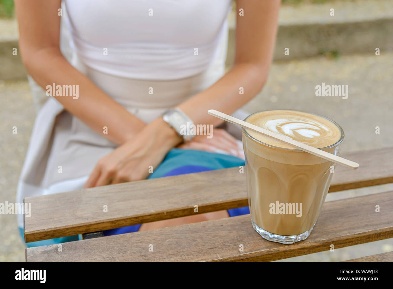 Avec la tasse de café latte art sur une table en bois avec girl sitting Banque D'Images