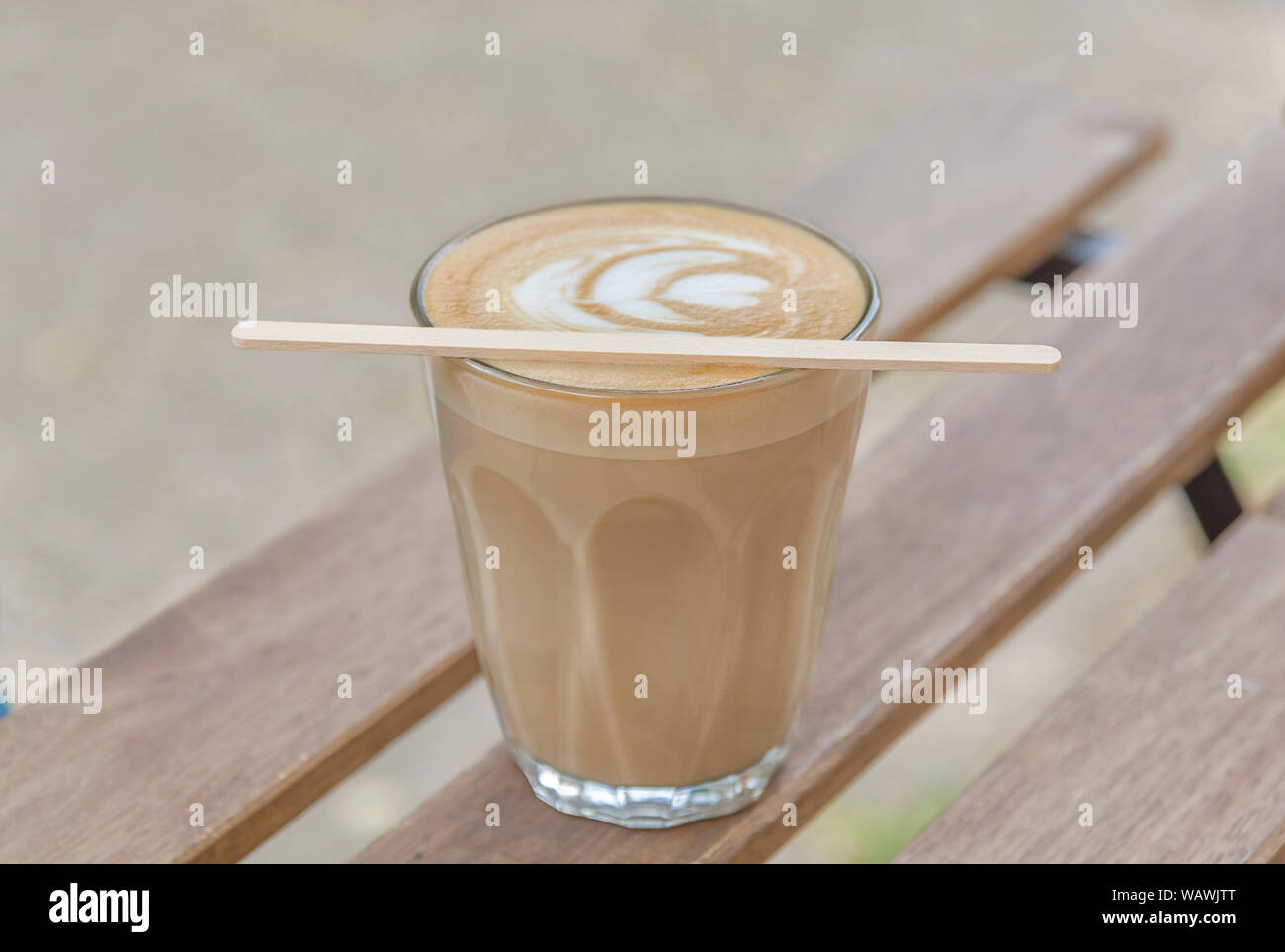 Avec la tasse de café latte art sur une table en bois Banque D'Images