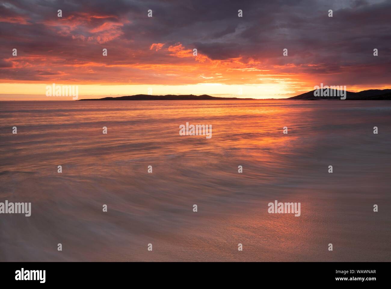 L'exécution des vagues sur une plage de sable fin, ciel nuageux avec coucher de soleil spectaculaire sur l'océan Atlantique, Isle of Harris, Scotland, United Kingdom Banque D'Images