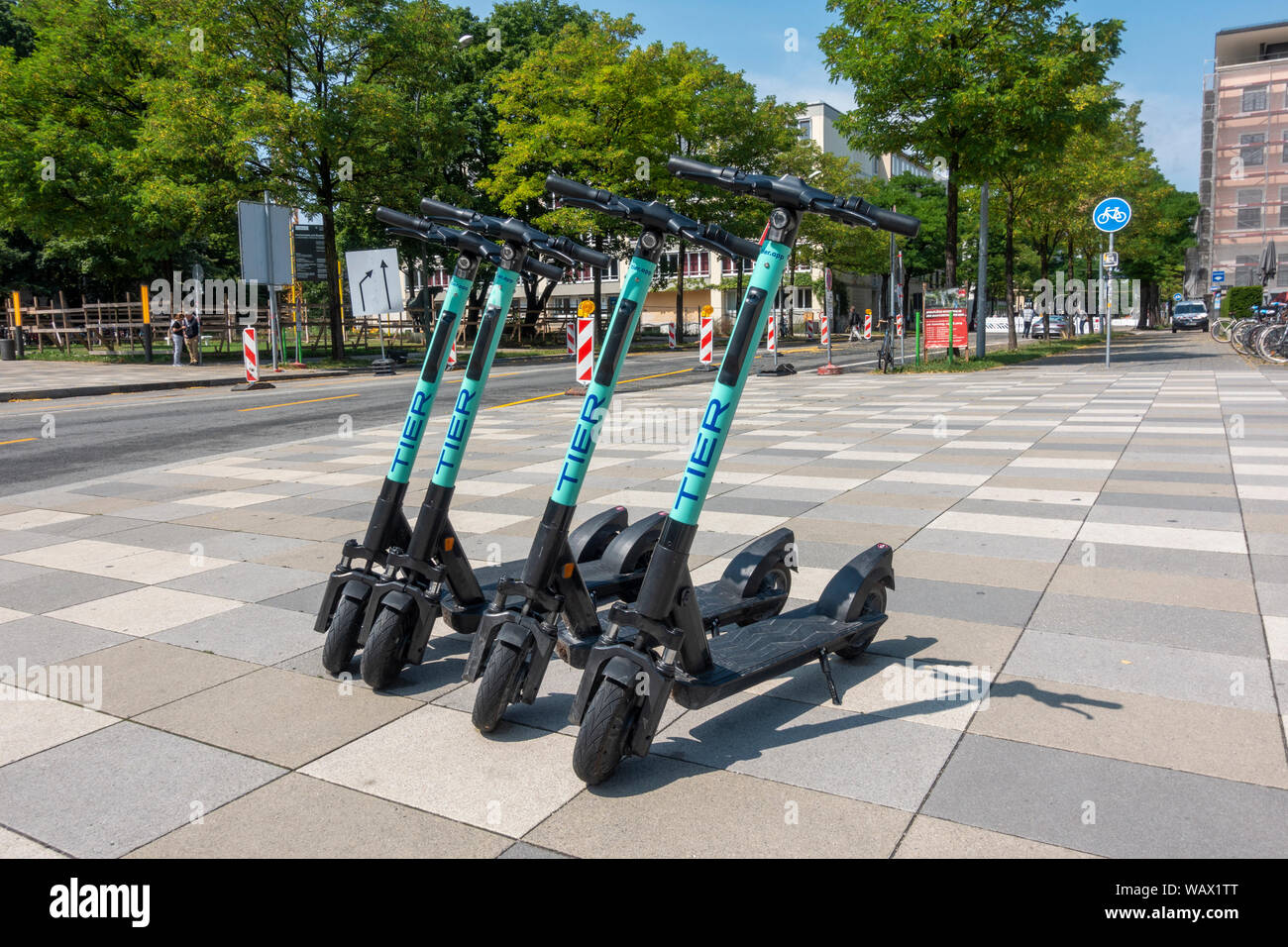 Niveau quatre scooters électriques kick-garé sur le trottoir à Munich, Allemagne. Banque D'Images