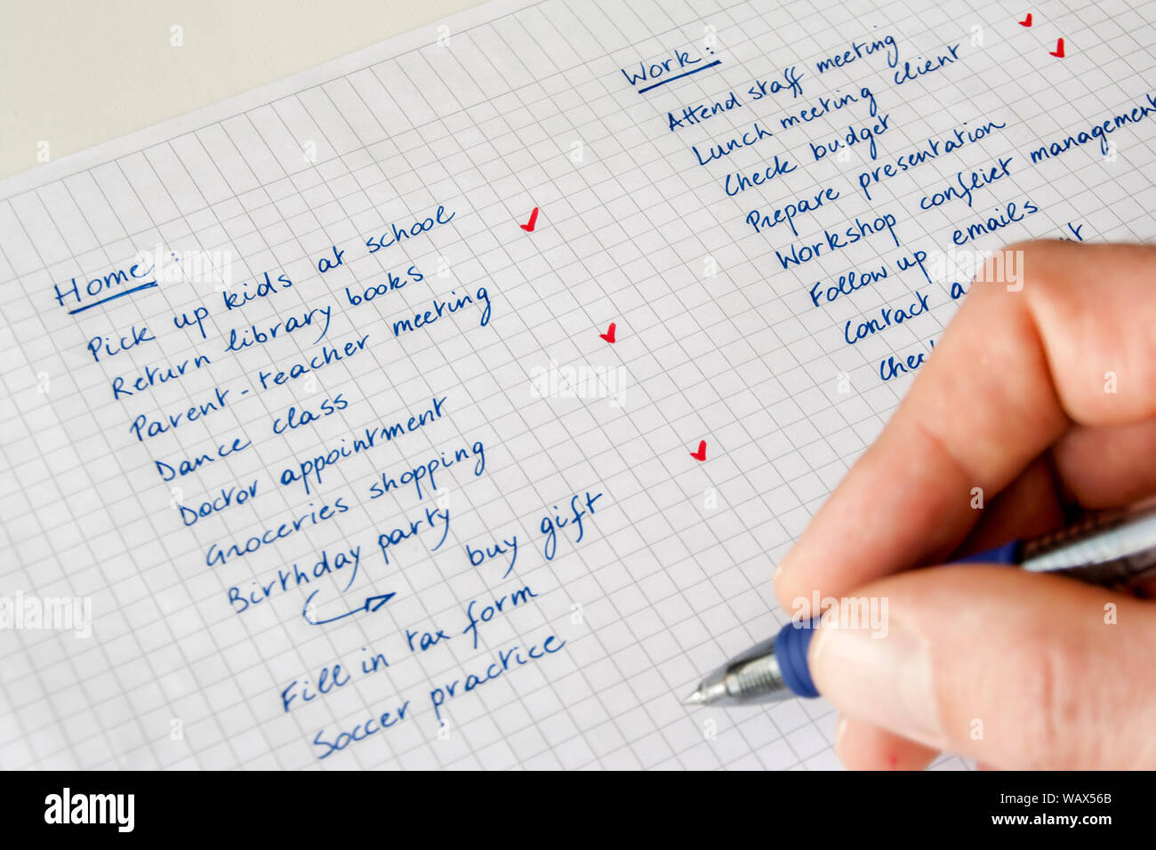 Liste des tâches. Concept d'équilibre travail/vie privée. Gros plan de la main d'un homme avec un stylo qui garde une liste manuscrite de tâches liées à la maison et au travail. Banque D'Images