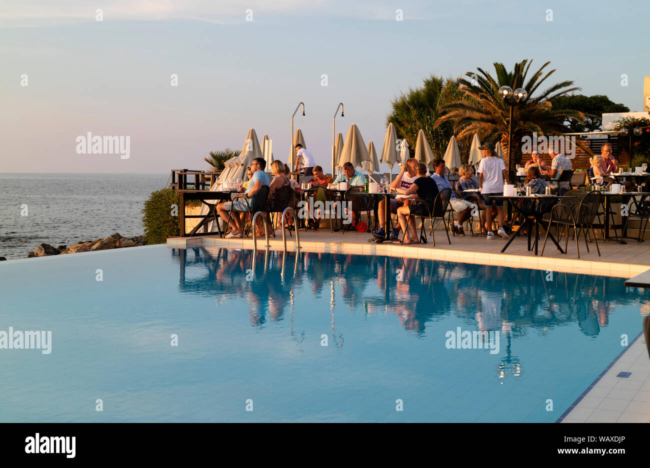 Crète, Grèce. Vous pourrez manger autour d'une piscine de l'hôtel près de coucher du soleil. Banque D'Images
