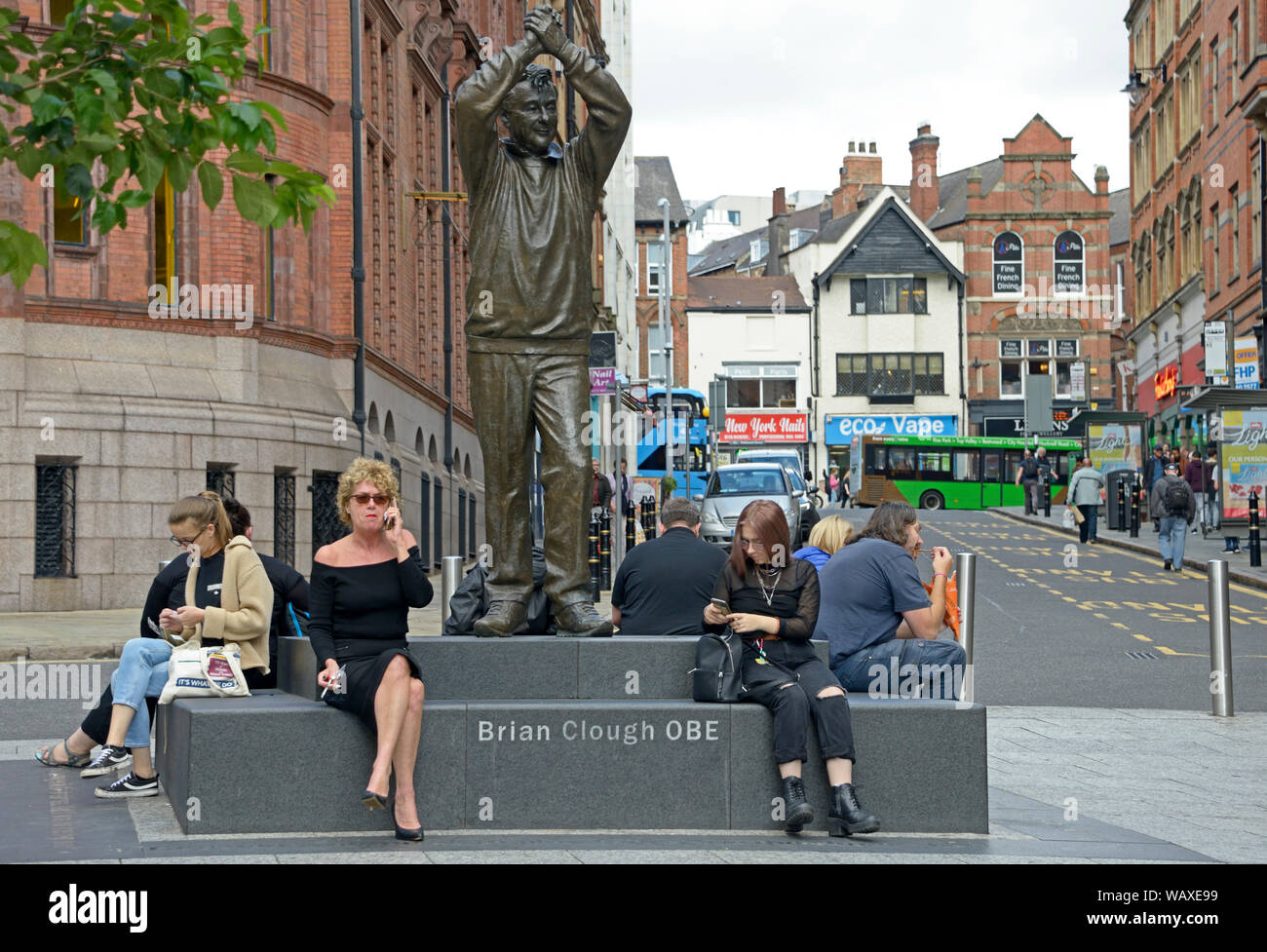 Les gens sur les téléphones de Brian Clough statue. Banque D'Images