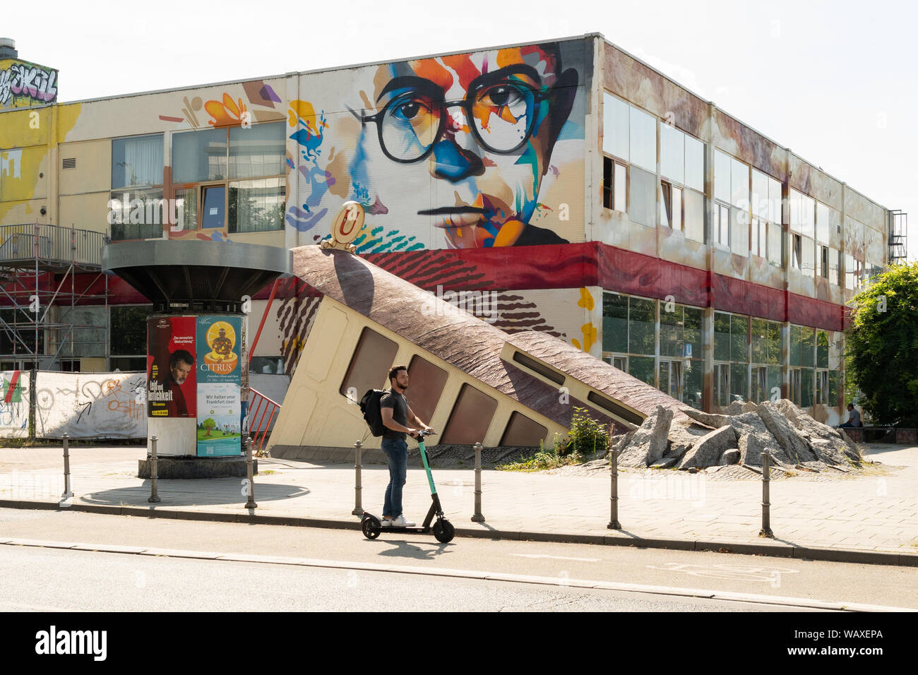 Sur l'homme e scooter dernière entrée de la station de métro Bockenheimer Warte et fresque de Michel Murat sur Labsaal bâtiment du campus, Francfort, Allemagne Banque D'Images