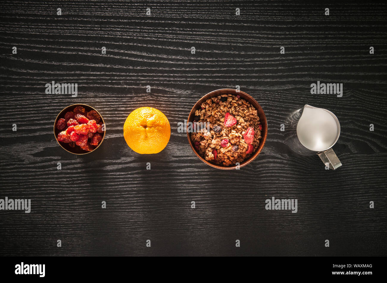 Petit-déjeuner sain avec des fruits muesli muesli. Et le lait dans un bol en bois sur fond noir en bois Vue supérieure avec copie espace Banque D'Images