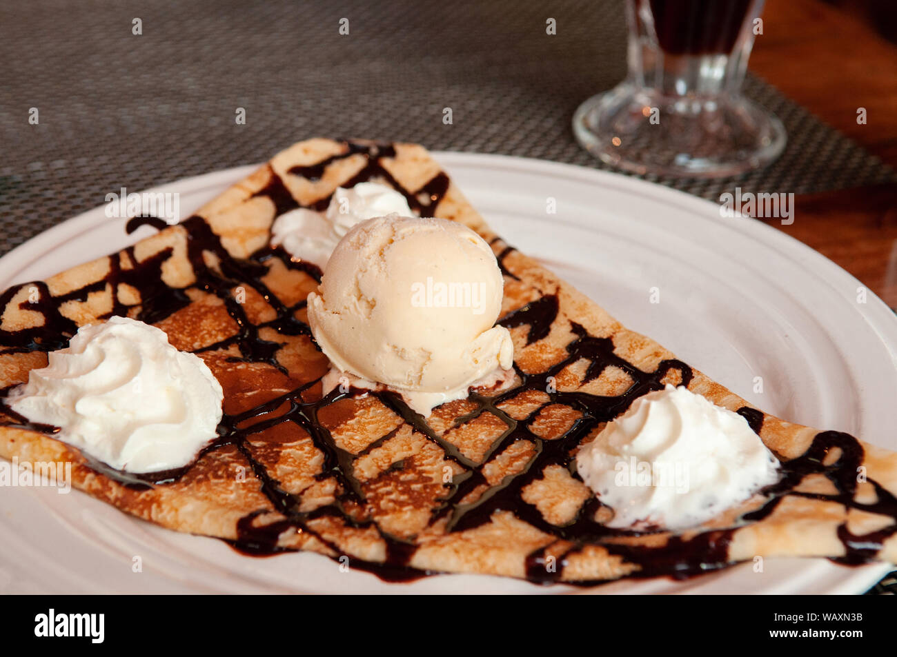 Pâte à crêpe simple français chaud avec de la glace vanille et crème fouettée sur plaque blanche - close up Banque D'Images