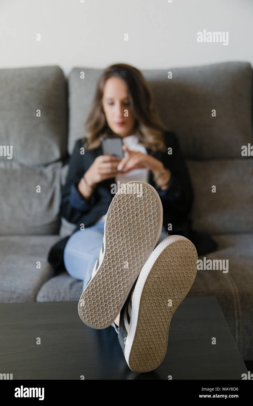 Femme d'affaires dans une table avec ses pieds sur une table Banque D'Images