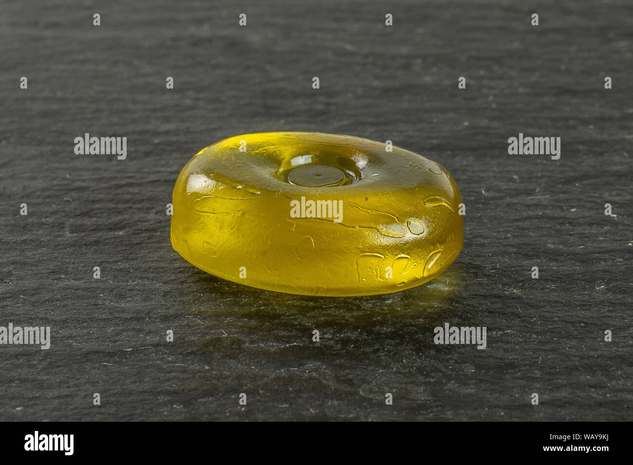 Un ensemble coloré jaune bonbon dur sur la pierre grise Banque D'Images