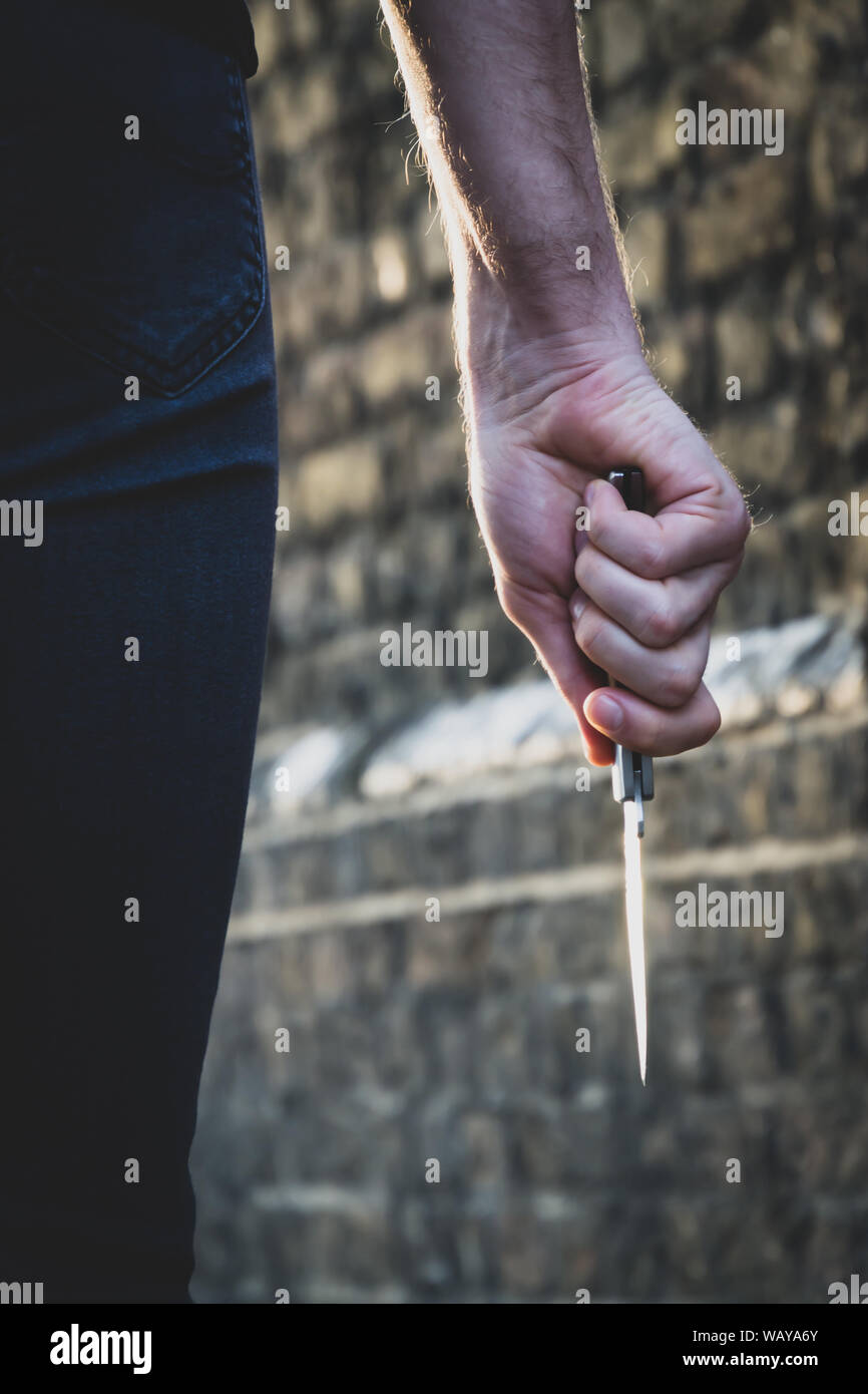 Vol qualifié crime concept. Un voleur ou un tueur personne avec un couteau pointu sur le point de commettre un homicide, le meurtre des paysages. Banque D'Images
