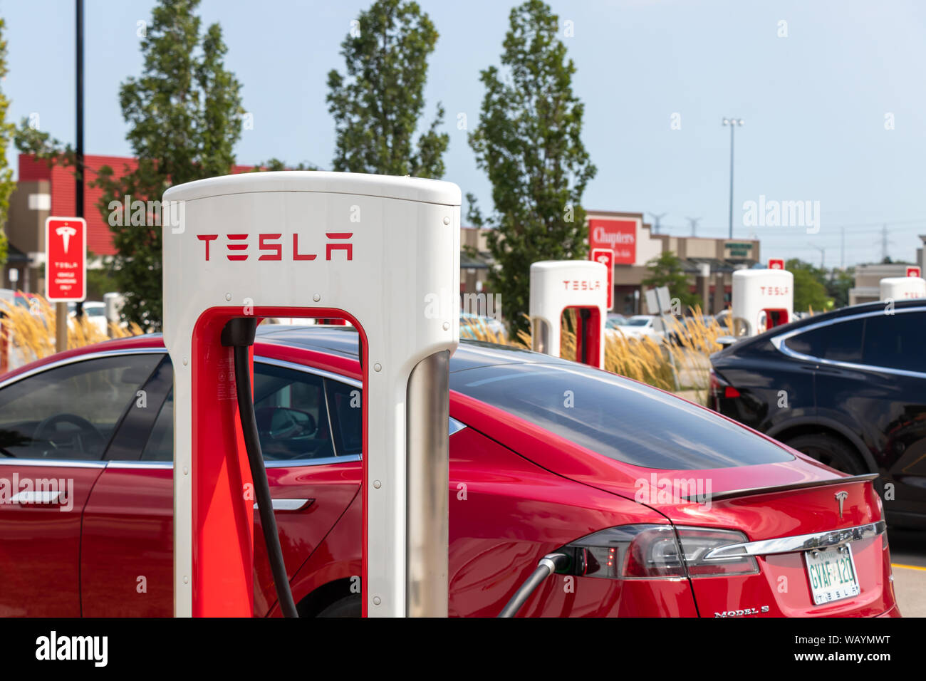 Tesla Décrochage compresseur vu pendant qu'une Tesla Model S rouge est branché-in et de charge. Banque D'Images Tesla Décrochage compresseur vu pendant qu'une Tesla Model S rouge est branché-in et de charge. Banque D'Images