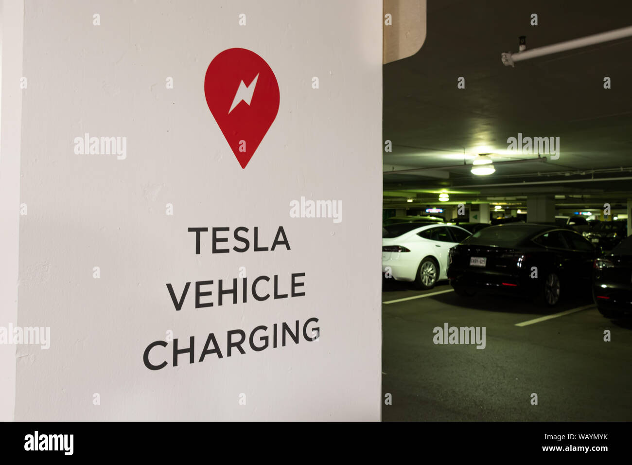 Véhicule Tesla signe de charge dans le garage de stationnement à la station a de Tesla. Banque D'Images Véhicule Tesla signe de charge dans le garage de stationnement à la station a de Tesla. Banque D'Images