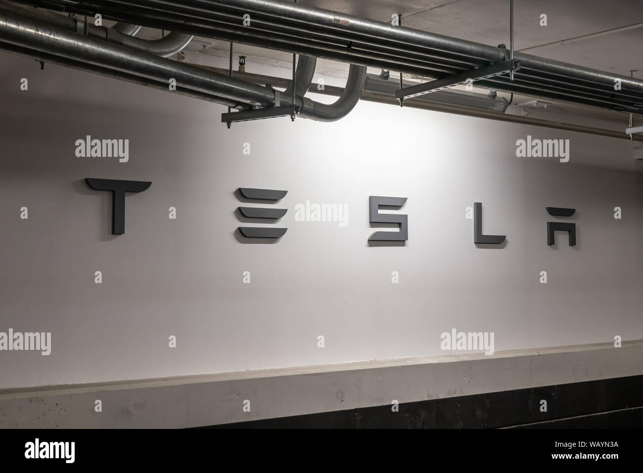 Logo texte Tesla Tesla retour à la station de compresseur dans un parking couvert au centre commercial Eaton de Toronto. Banque D'Images Logo texte Tesla Tesla retour à la station de compresseur dans un parking couvert au centre commercial Eaton de Toronto. Banque D'Images