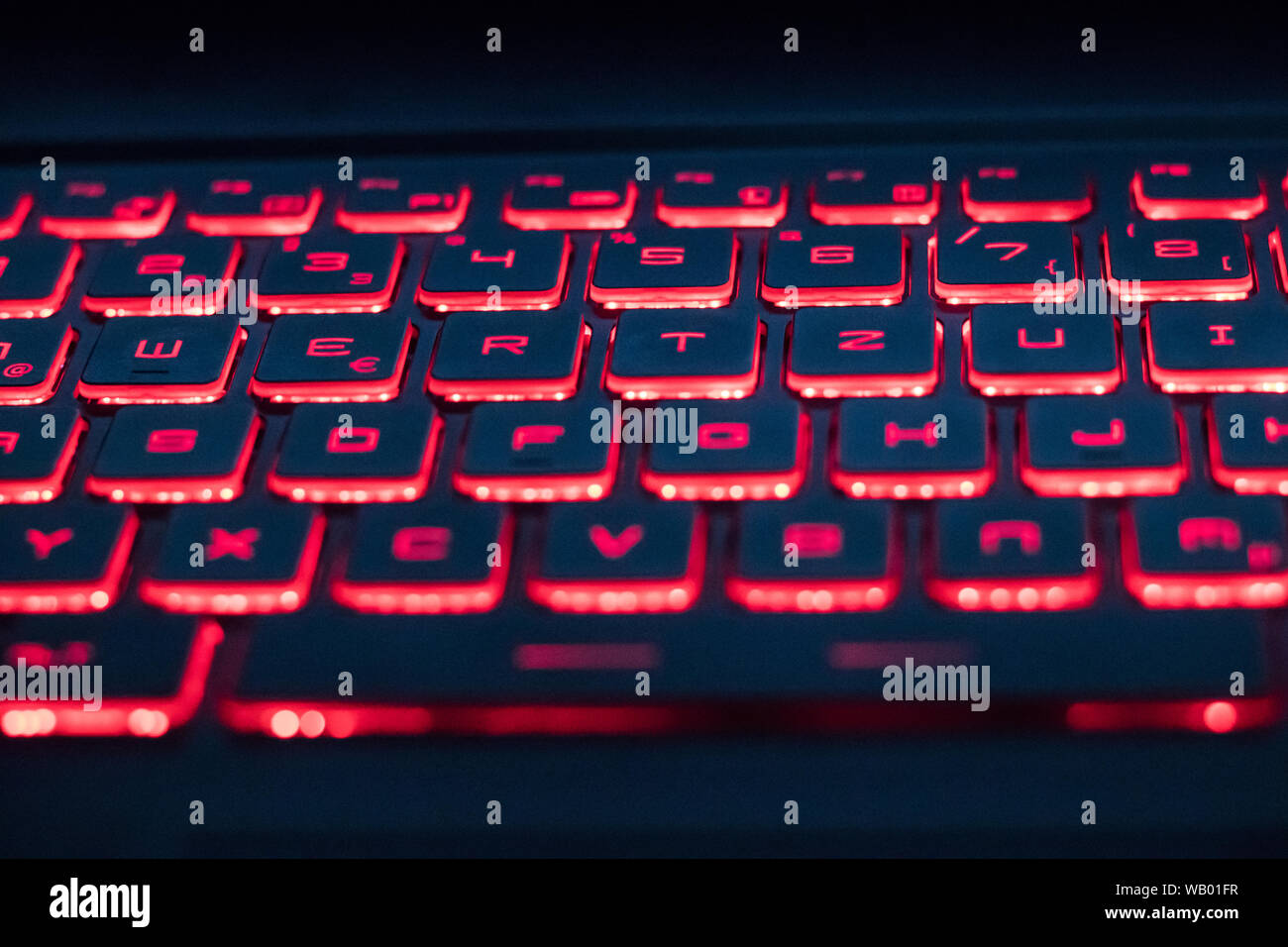 Clavier d'ordinateur rétroéclairé en rouge dans l'obscurité Banque D'Images