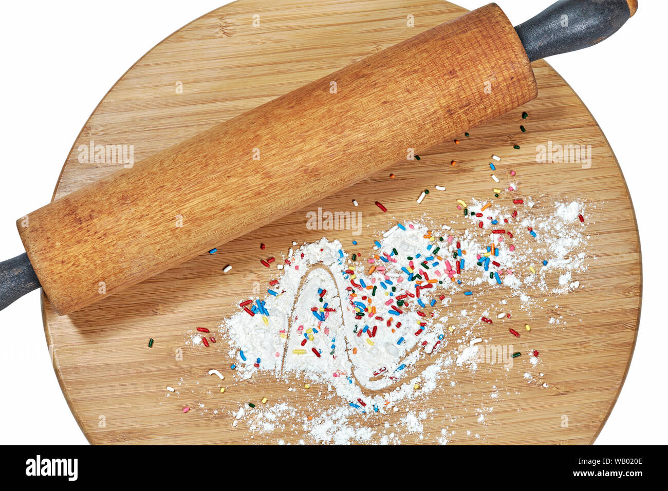 Un rouleau à pâtisserie en bois sur une planche à découper en bambou avec de la farine blanche et multicolore arrose au conseil isolated on white Banque D'Images