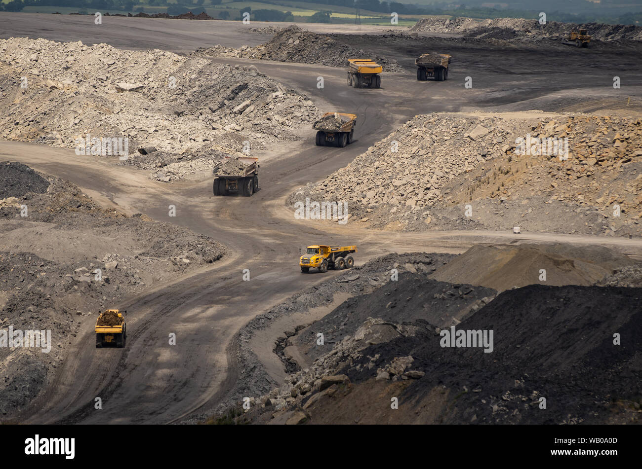 Les camions miniers jaune travaillant dans une mine à ciel ouvert la carrière de Blagdon dans le Nord Est de l'Angleterre. Banque D'Images