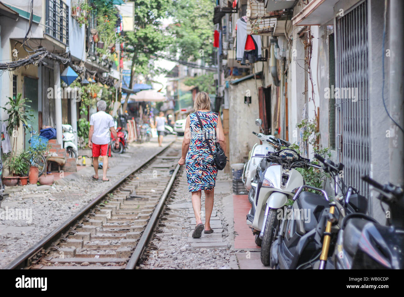 Une femme marche sur le chemin de fer en train street, Hanoi, Vietnam Banque D'Images