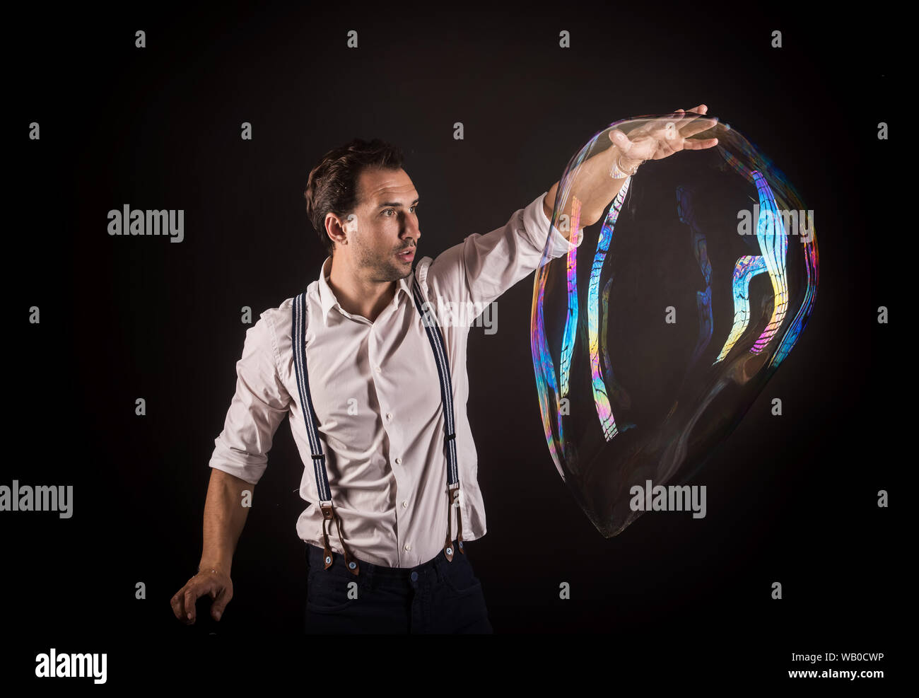 Artiste tenir grande bulle de savon dans ses mains. Bubble show studio concept. Banque D'Images