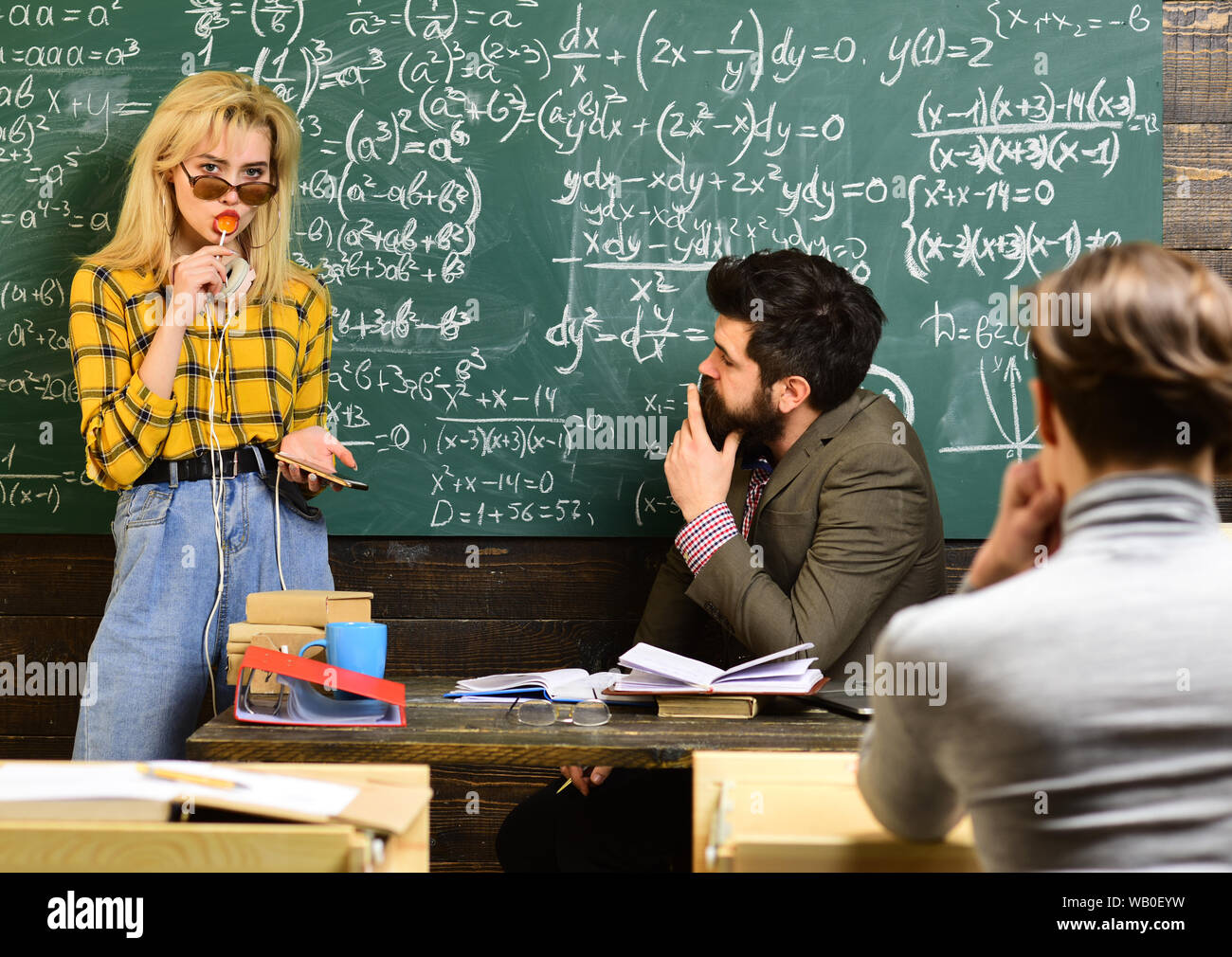 Tuteur devra réévaluer les objectifs des étudiants. Professionnels formés qui enseigne le groupe d'étudiants. Étudiants assis ensemble à table. Banque D'Images