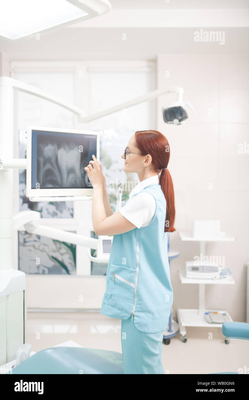 Red-haired dentiste avec queue de l'étude X-ray de patient Banque D'Images