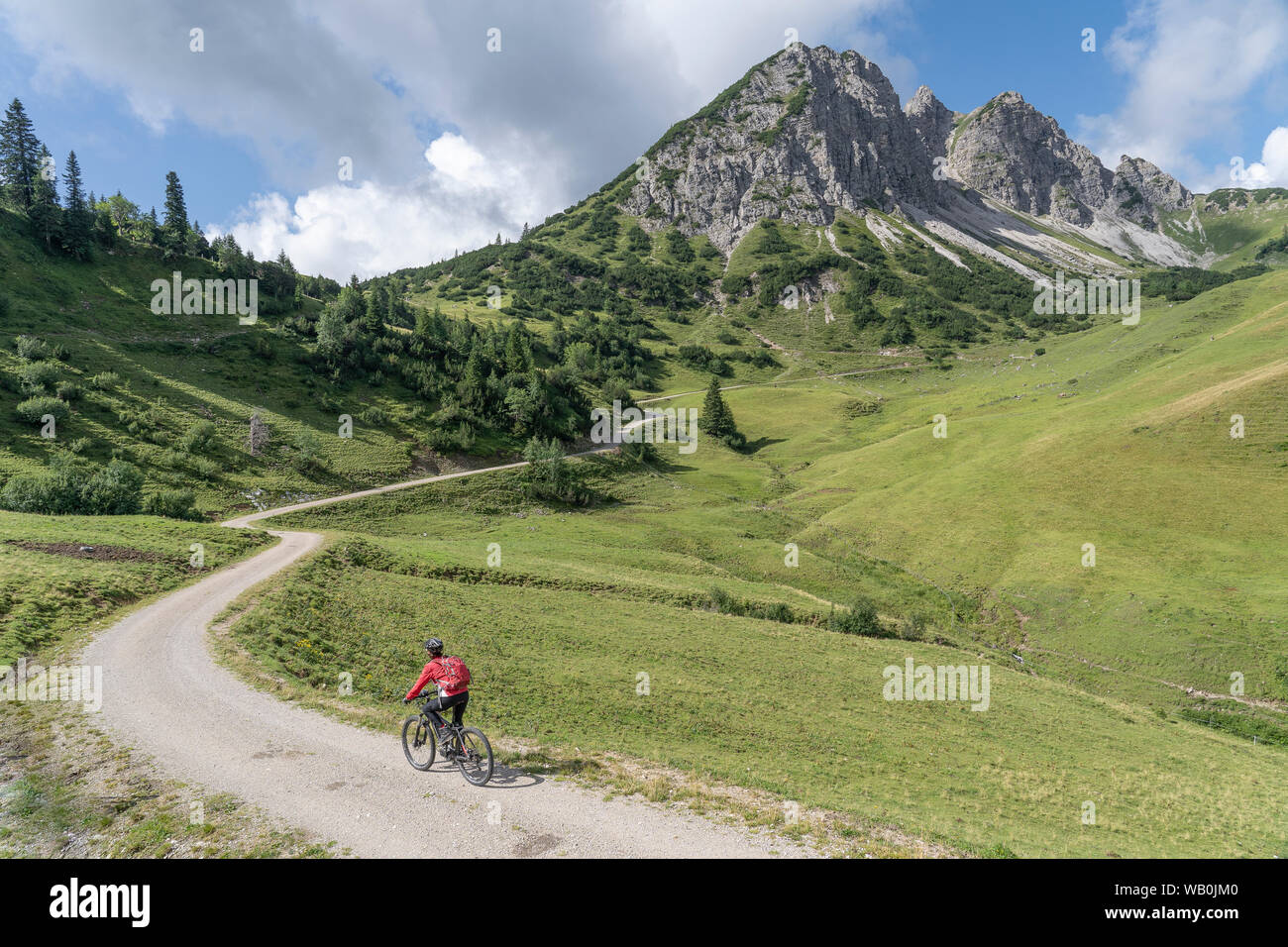 Belle et active femme senior, à cheval son vélo e-montagne dans la vallée de Tannheim sur le sentier jusqu'à Litnis Schrofen , Tyrol, Autriche, Banque D'Images