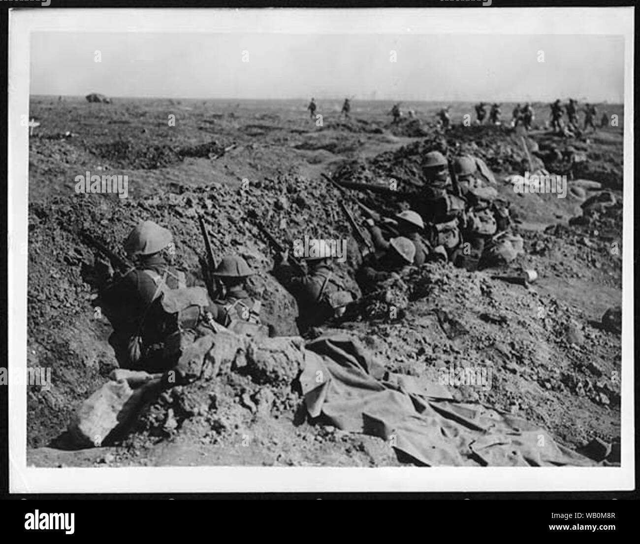 En attente d'infanterie dans une tranchée pour leur tour à l'avance, tandis que d'autres à droite sont déjà en marche. Il y a un réservoir dans l'arrière-plan sur l'infanterie, de sorte que l'image doit avoir été prises après le 15 septembre 1916, la première fois que les chars ont été utilisés dans la bataille. Elle date probablement d'après l'offensive de Cambrai, 1917 lorsqu'ils ont été utilisés avec plus de succès. Haig avait initialement été enthousiasmés par les chars, mais il a été forcé de les utiliser trop tôt en 1916, avec des résultats désastreux. En 1917, la tactique avait été pratiqué, avec les réservoirs utilisés à titre d'avance de briser l'ennemi" Banque D'Images