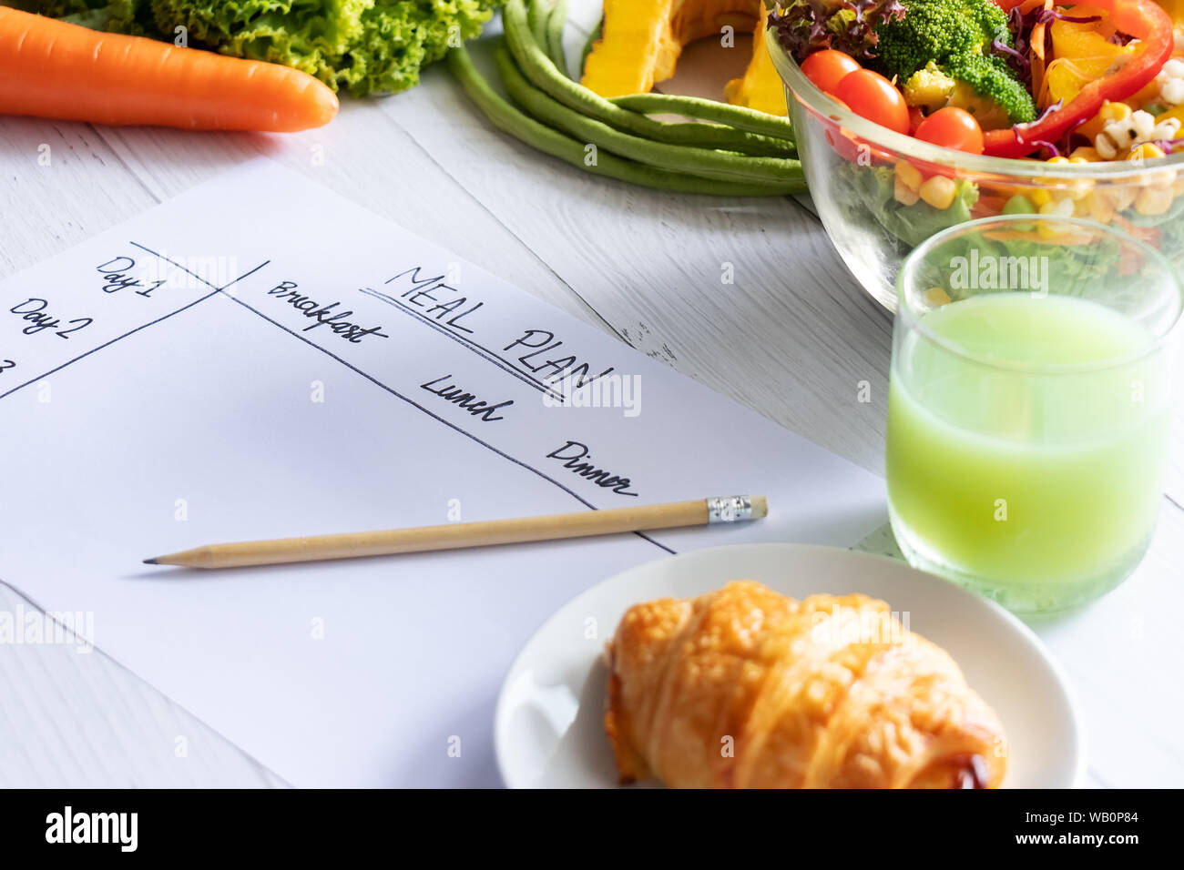 Le contrôle des calories, repas, régime alimentaire et perte de poids concept. Vue de dessus de table repas sur papier avec salade, jus de fruits, pain et légumes Banque D'Images