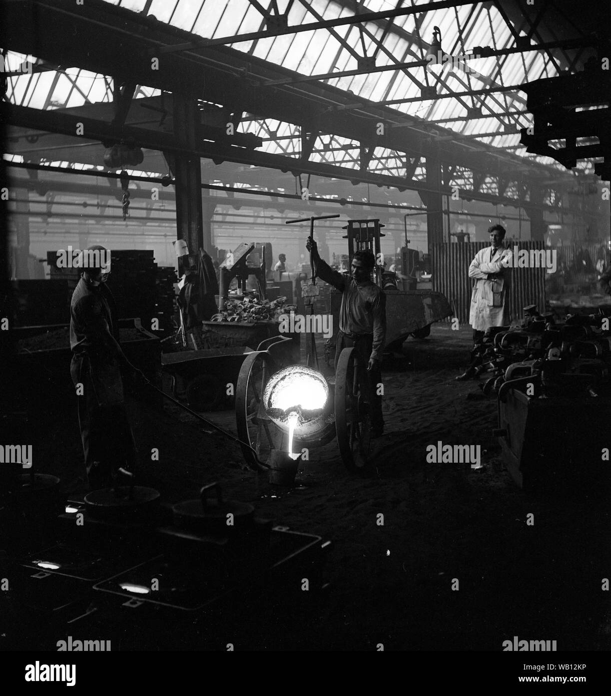 Les travailleurs de la fonderie de fer pouring molten metal Grande-bretagne 1964 Banque D'Images