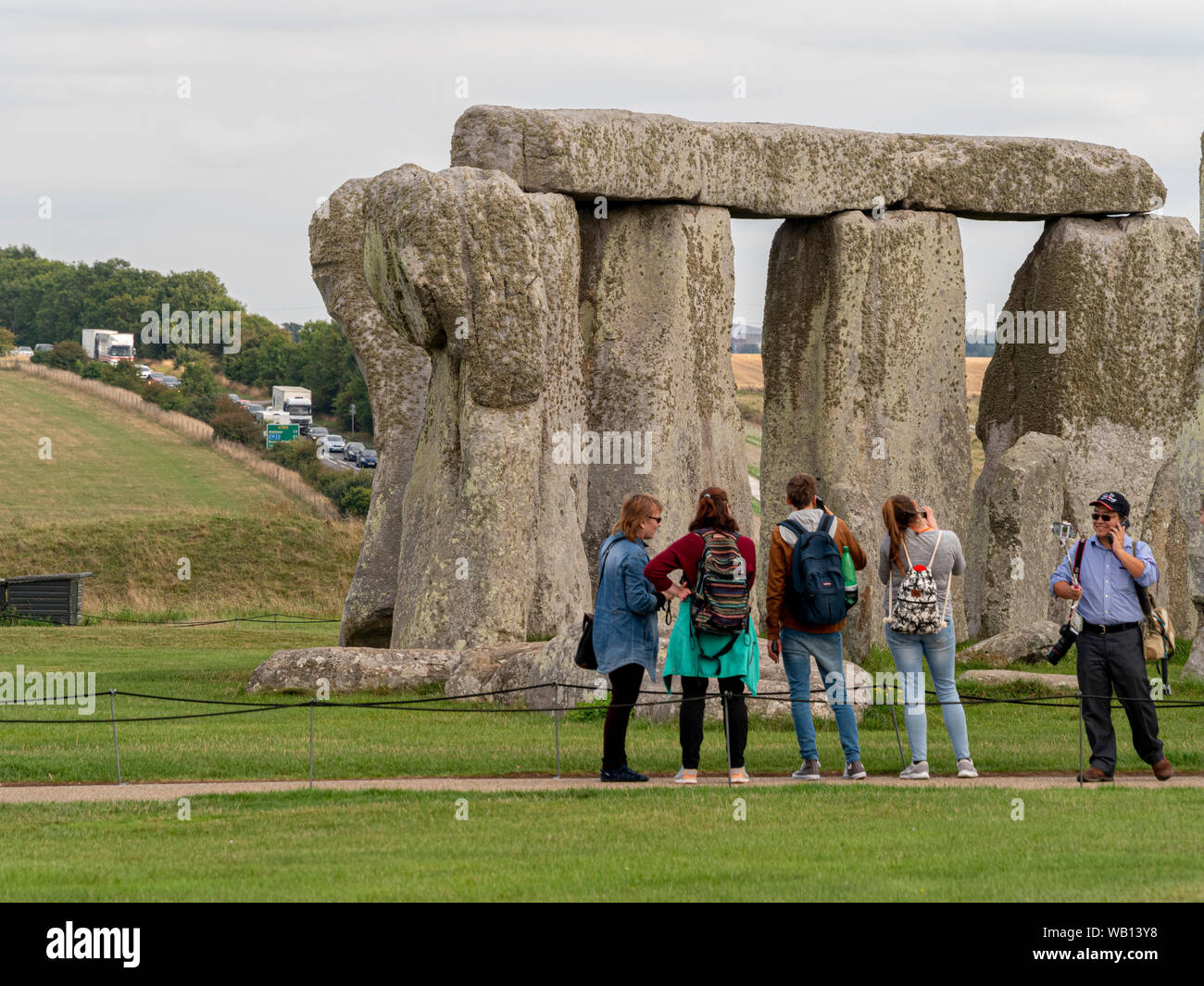 Stonehenge avec les touristes et l'A303 visible à l'arrière-plan, Wiltshire, Angleterre. Banque D'Images