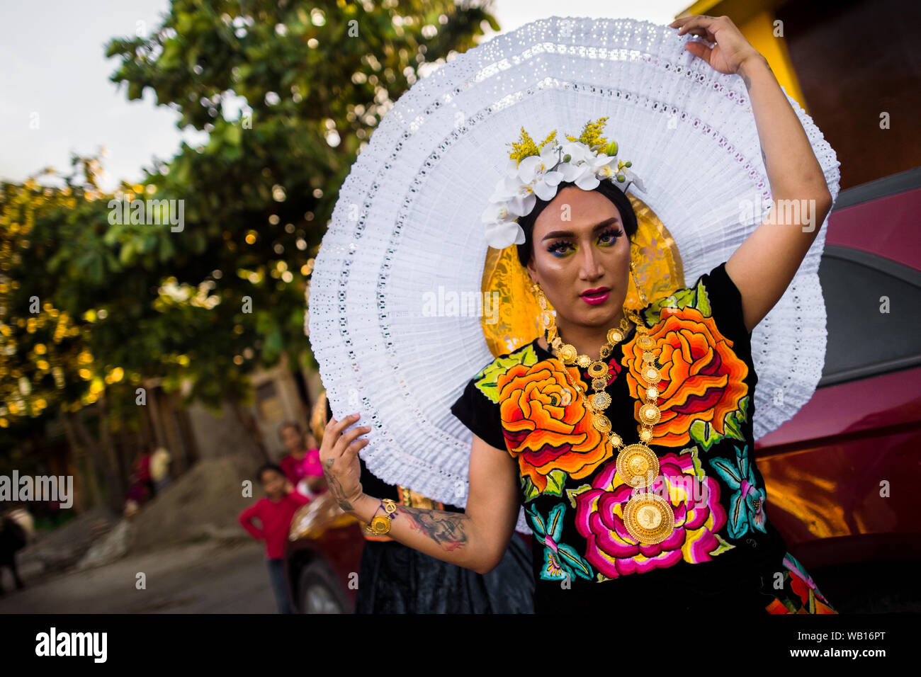 Un Mexicain "muxe" (typiquement, un homosexuel homme portant les vêtements féminins) règle une coiffe pendant le festival à Juchitán de Zaragoza, Mexique. Banque D'Images