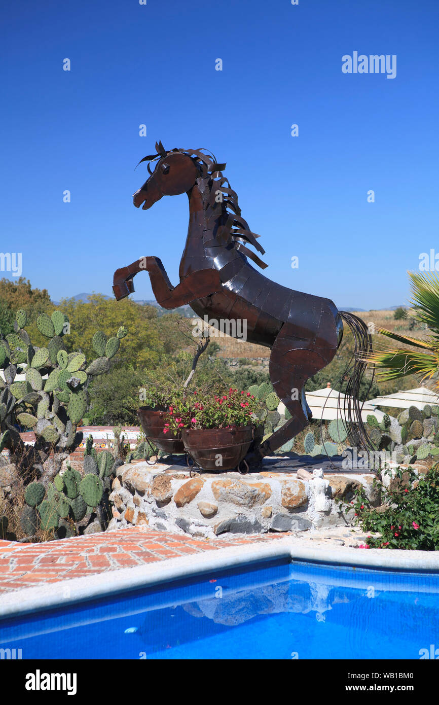 Une sculpture d'un cheval dansant à côté d'une piscine d''un complexe de luxe/villa Banque D'Images