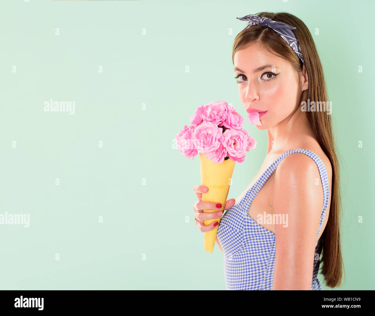 Jolie fille à l'esprit vintage. pinup girl avec mode de cheveux. fleurs''. Fleuriste. L'été. pin up femme avec un miroir très tendance. retro woman eating ice c Banque D'Images