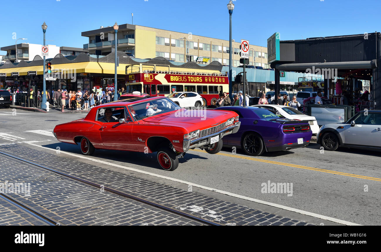 SAN FRANCISCO, CALIFORNIE / USA - 30 avril 2017 : les Américains d'origine mexicaine au volant d'une Chevrolet Impala lowrider rouge dans les rues de San Francisco. Banque D'Images